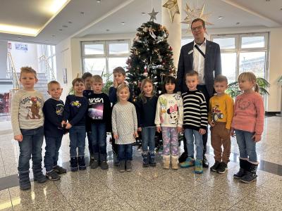 Kinder mit Bürgermeister Reinders vor dem geschmückten Weihnachtsbaum
