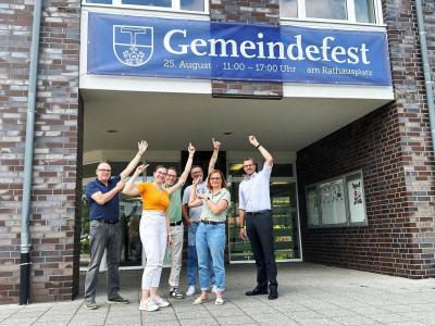 Foto von Bürgermeister und Ratsmitglieder mit Hinweis (Banner) auf das Gemeindefest